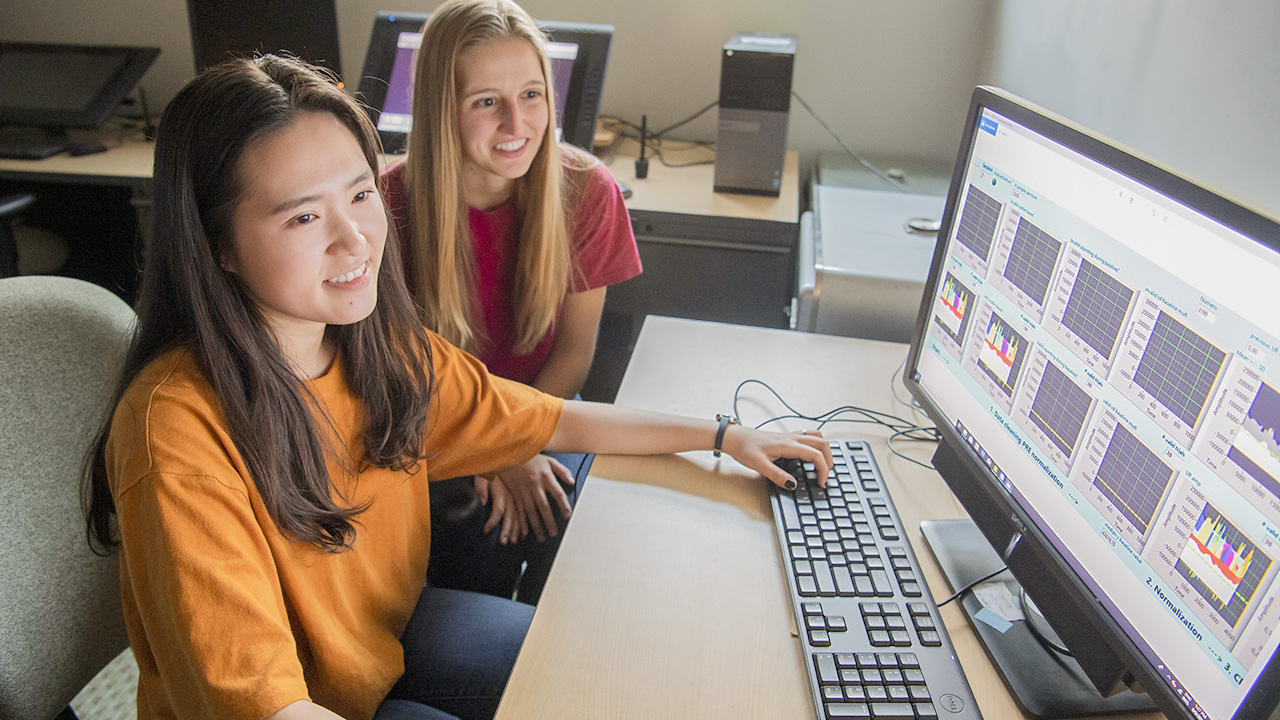 Two students working on a computer together.