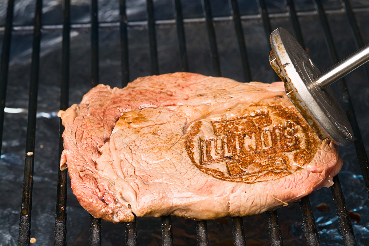 Steak on grill with Illinois brand.