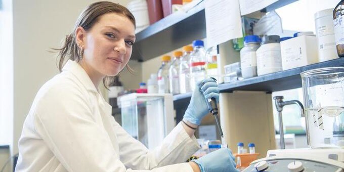 Student holding a pipette in a lab