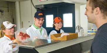Students selling steak to a customer in the Meat Science Lab