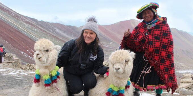 Study abroad student in mountains with alpacas