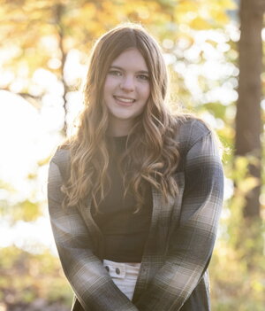 brunette girl posed outside in flannel shirt