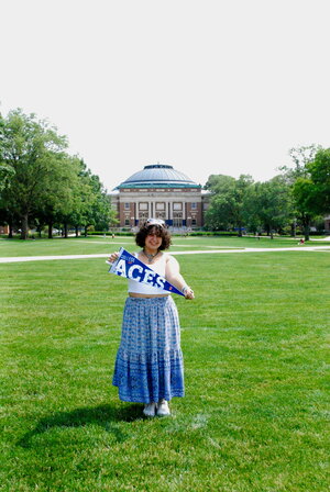 A person in blue dress on grassy area. 