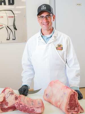 Portrait of Daniel Clark cutting meat